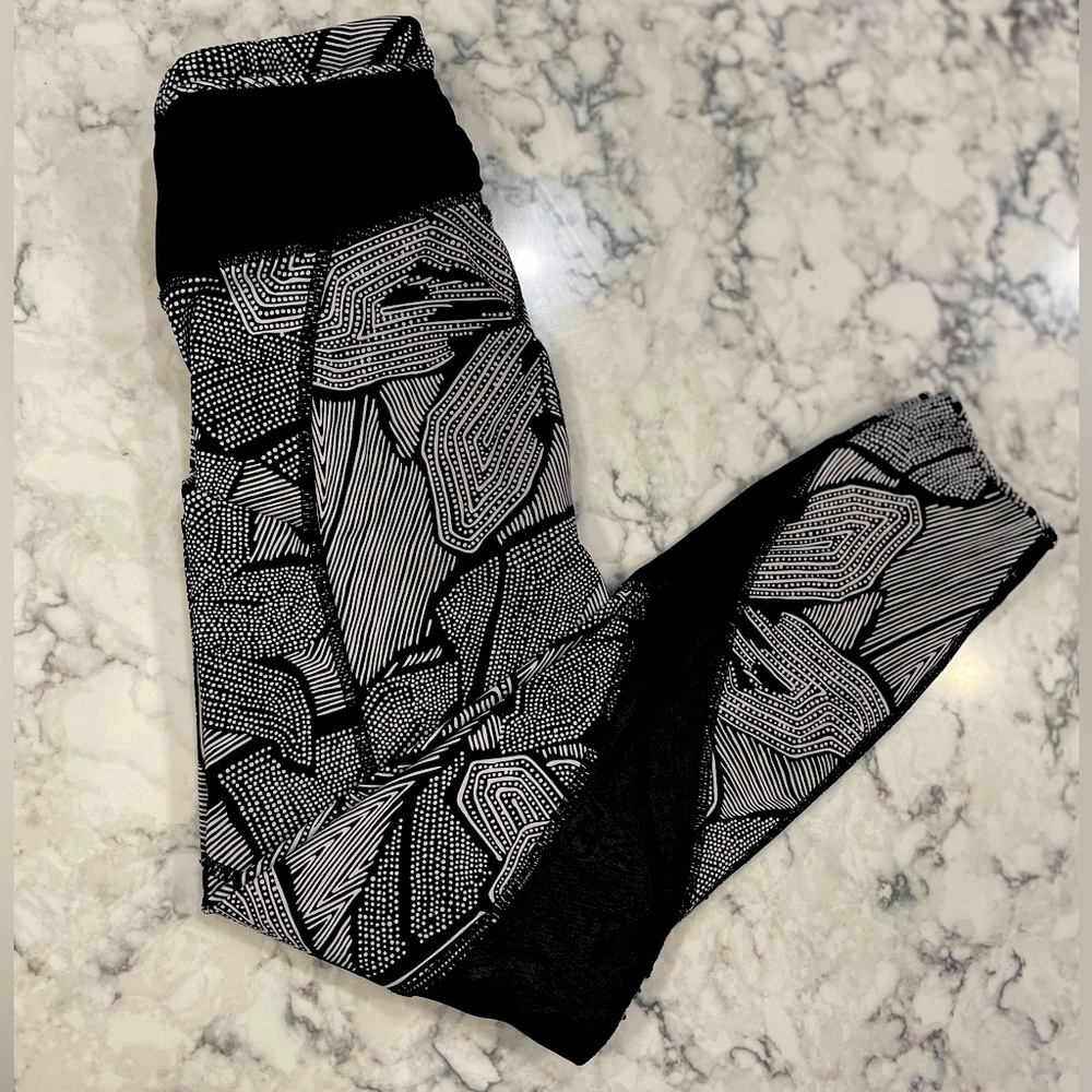 Lululelon black and white athletic leggings. Size 2, which mesh pockets on side.